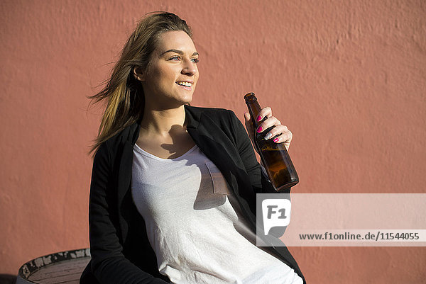 Porträt einer entspannten Frau mit Bierflasche