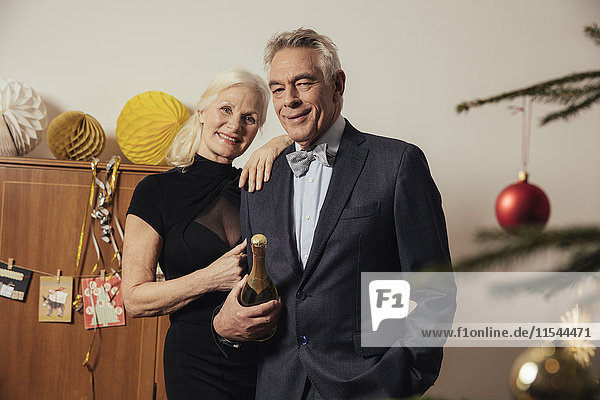 Senior Paar hält Flasche Champagner an New Yeras Eva