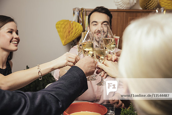 Lachende Freunde  die an Silvester mit Champagner anstoßen