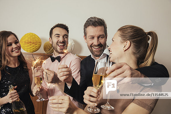 Freunde feiern gemeinsam Silvester und trinken Champagner.