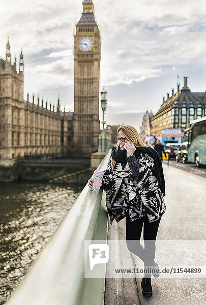 UK  London  junge Frau am Telefon an der Westminster Bridge