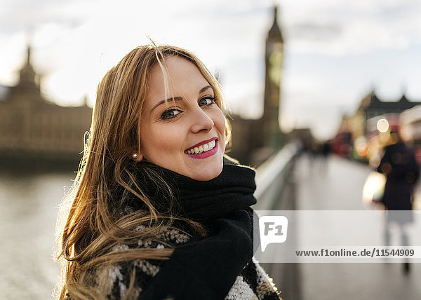 UK  London  Porträt der lächelnden jungen Frau auf der Westminster Bridge