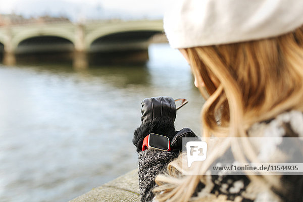 UK  London  junge Frau mit ihrer Smartwatch bei der Westminster Bridge