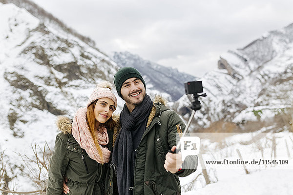 Spain  Asturias  couple taking selfie in the snowy mountains