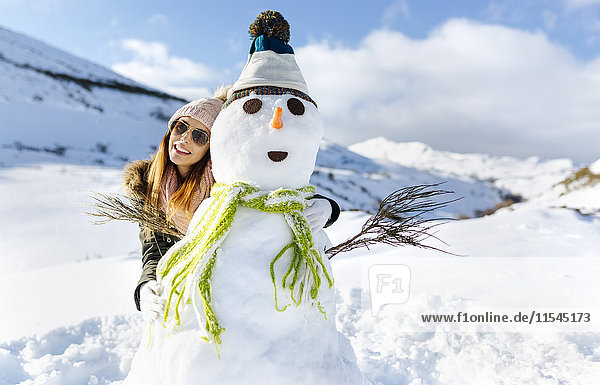 Spanien  Asturien  glückliche junge Frau mit Schneemann