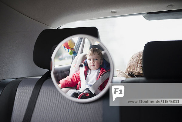 Spiegelung des Kleinkindes im Kindersitz im Auto