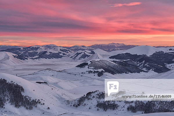 Italien Umbrien Nationalpark Monti Sibillini Sonnenuntergang auf dem Plateau Piano Grande von Castelluccio di Norcia im Winter