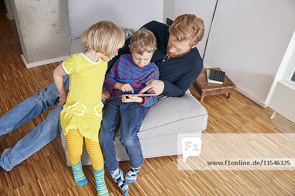 Father and two children using digital tablet
