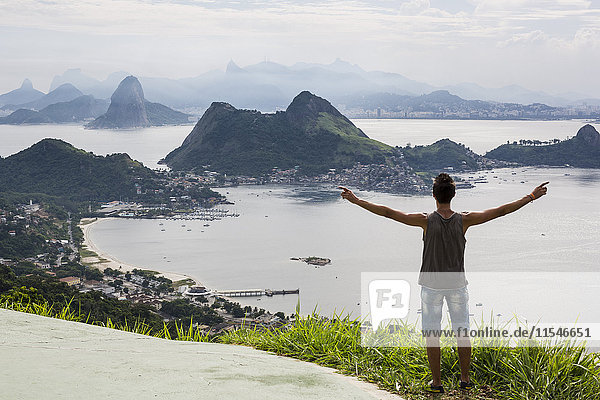 Brazil  Rio de Janeiro  tourist standing at view point  raising arms