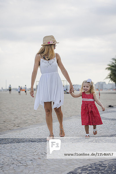 Brasilien  Rio de Janeiro  Mutter und Tochter beim Spaziergang am Strand von Copacabana