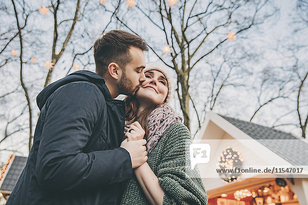 Man kissing woman on the cheek on the Christmas Market
