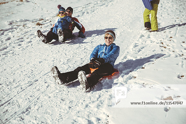 Italy  Val Venosta  Slingia  family sleighing down a snowy hill