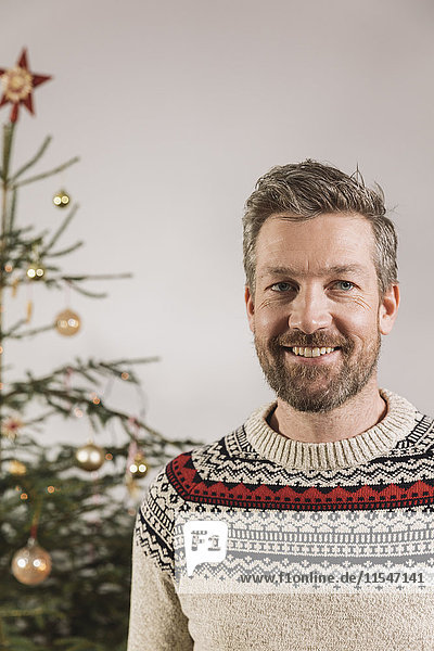 Porträt eines Mannes vor dem Weihnachtsbaum