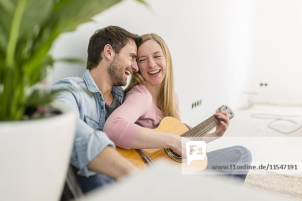 Happy couple playing guitar and singing