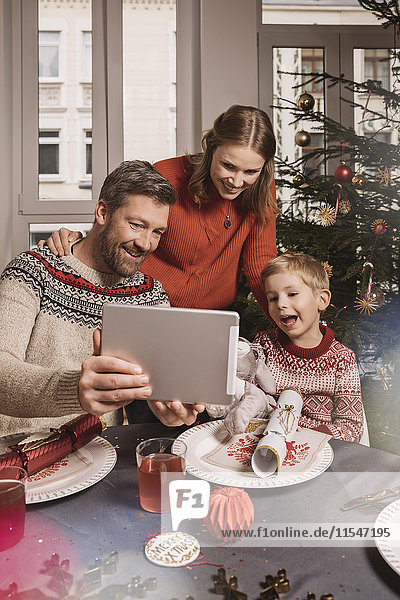 Family using digital tablet during Christmas