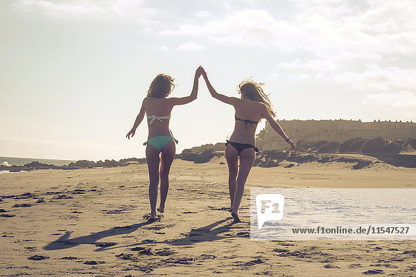 Spanien  Teneriffa  zwei Freundinnen beim Spaziergang am Strand