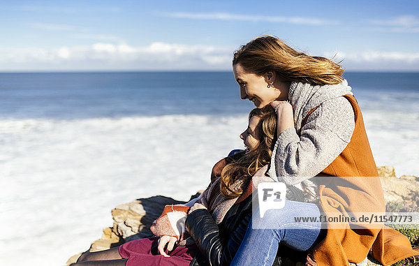 Spain  Gijon  two young women having fun near the sea