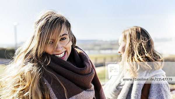 Porträt einer glücklichen jungen Frau mit Freund im Freien