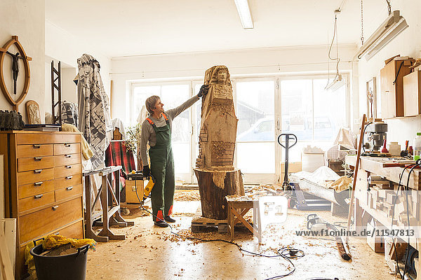 Wood carver in workshop working on sculpture