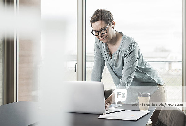 Businesswoman using laptop in office