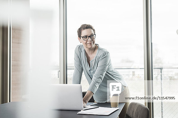 Businesswoman with laptop in office