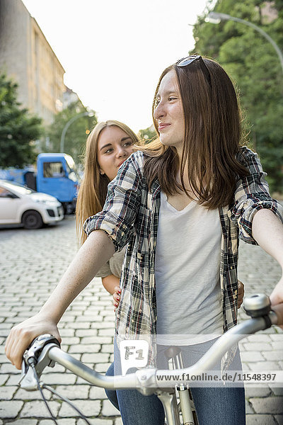 Zwei Teenager-Mädchen zusammen auf dem Fahrrad