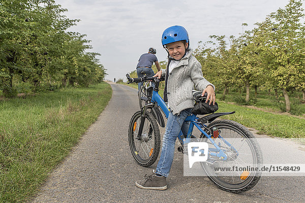 Portrait des kleinen Jungen auf Fahrradtour mit seinem Vater