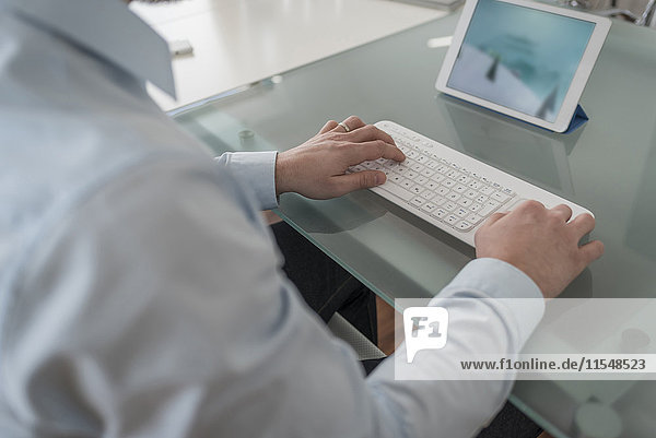 Mann mit Tastatur für digitales Tablett im Büro