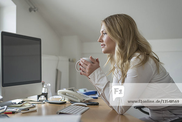 Junge Frau am Schreibtisch im Büro