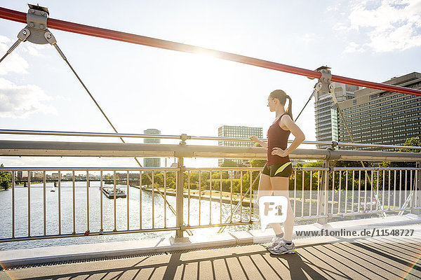 Deutschland  Frankfurt  junger Athlet auf der Brücke stehend mit Blick auf die Brücke