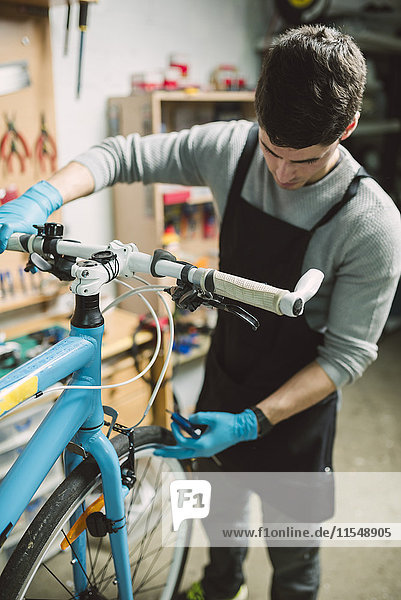Mechaniker bei der Reparatur eines Fahrrades in seiner Werkstatt