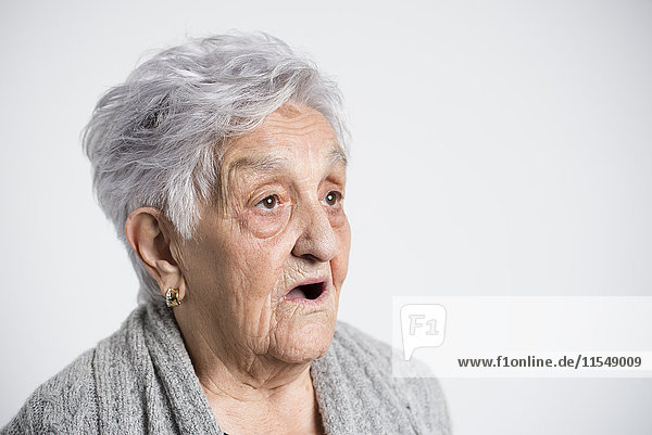 Portrait of surprised senior woman in front of white background