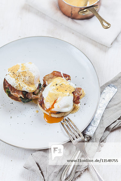 Egg Benedict mit englischen Muffins  pochierten Eiern  Schinken  geschmortem Spinat und Hollandaise