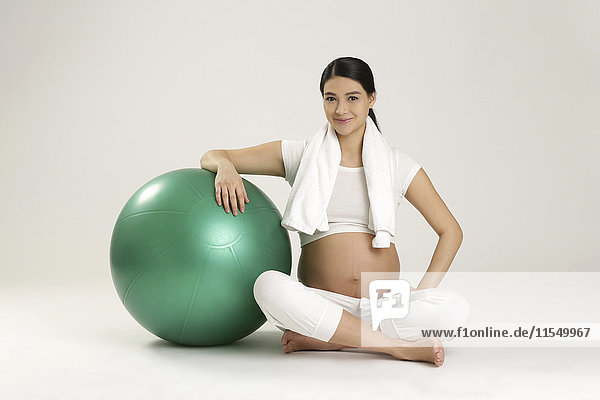 Lächelnde Schwangere mit Fitnessball