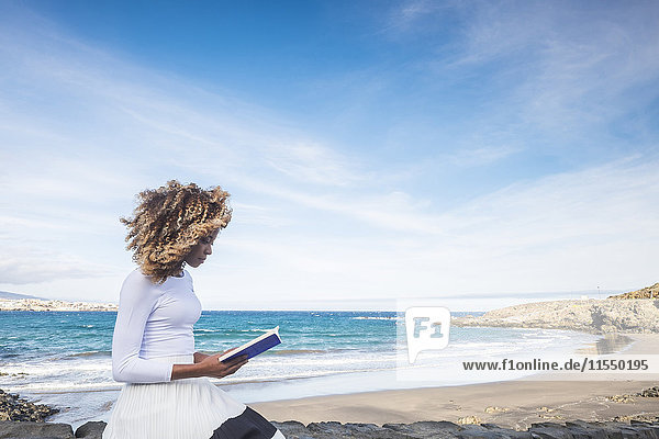 Spanien  Teneriffa  Frau beim Lesen eines Buches in Strandnähe