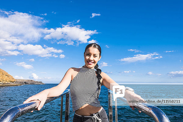 Spanien  Teneriffa  Porträt einer lächelnden jungen Frau vor dem Meer