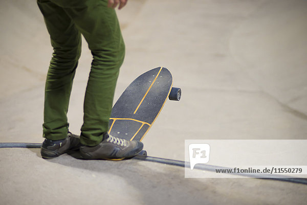 Beine eines jungen Mannes mit Skateboard