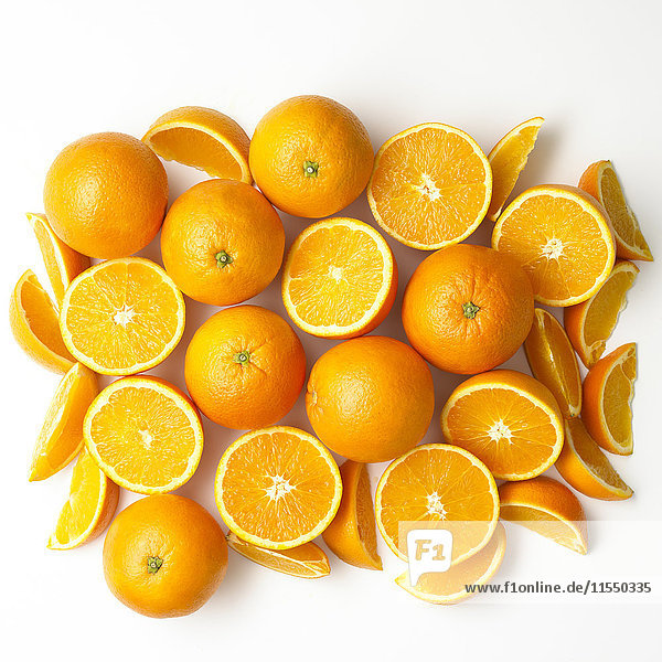 Ganze und geschnittene Orangen auf weißem Grund