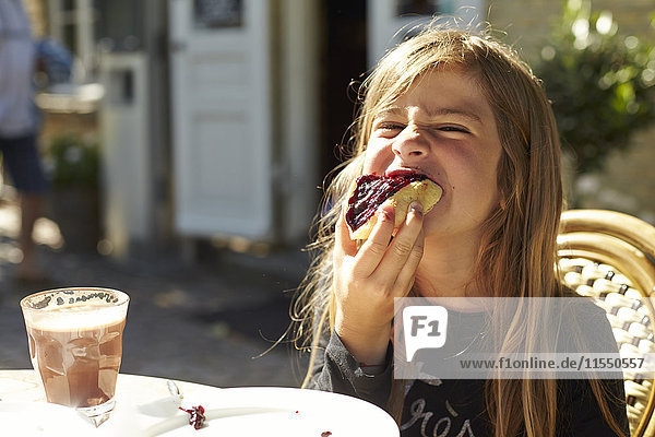 Porträt eines Mädchens  das Brot mit Marmelade isst.