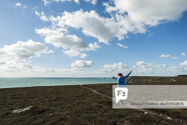 Frankreich  Bretagne  Finistere  Halbinsel Crozon  Frau  die an der Küste steht und einen Selfie nimmt.