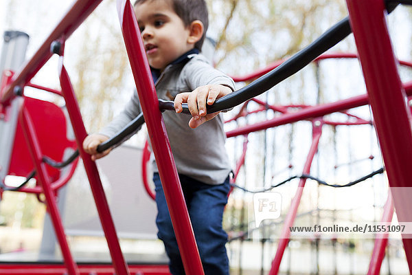 Toddler playing on red playground equipment