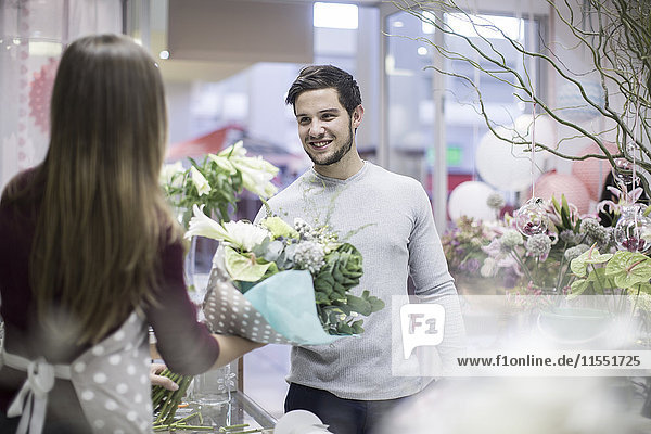 Mann kauft Blumen im Blumenladen