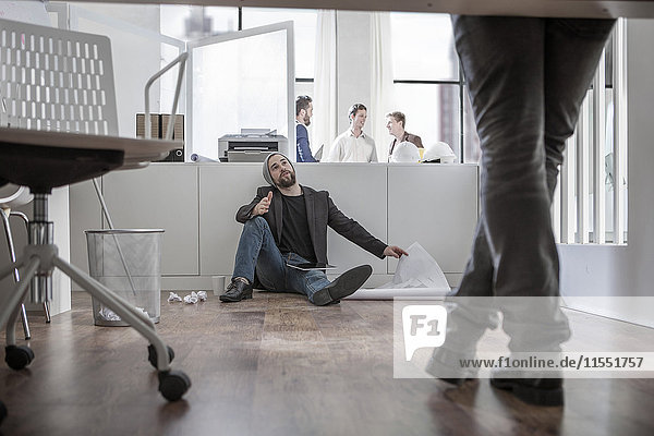 Creative professional sitting on office floor