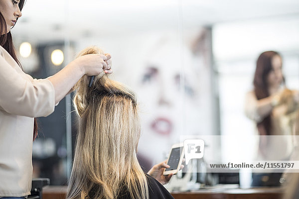 Friseur im Friseursalon prüft die Haare des Kunden