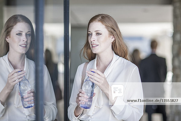 Young business woman drinking water