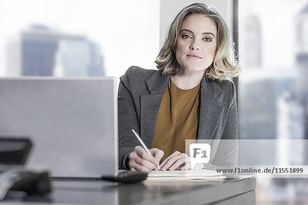 Porträt einer Frau am Schreibtisch schreiben