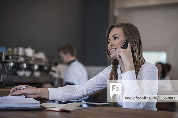 Young woman sitting at coffee bar working