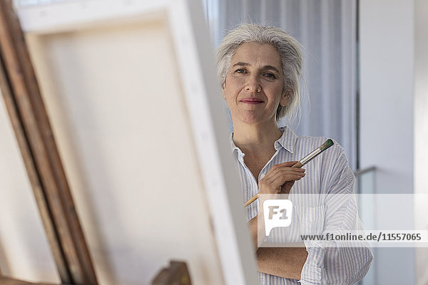 Porträt selbstbewusste reife Frau malt an Leinwand auf Staffelei