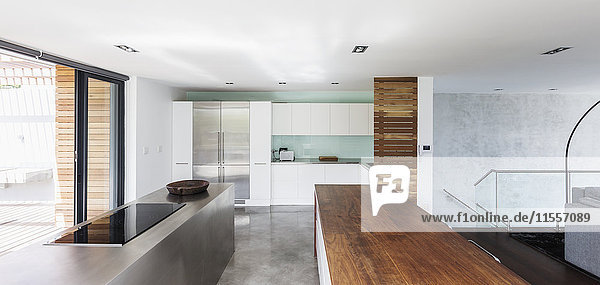 Modernes  minimalistisches Haus mit einer Küche mit Holz- und Edelstahltischen