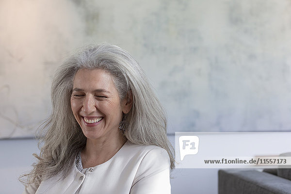 Ältere Frau lachend mit geschlossenen Augen